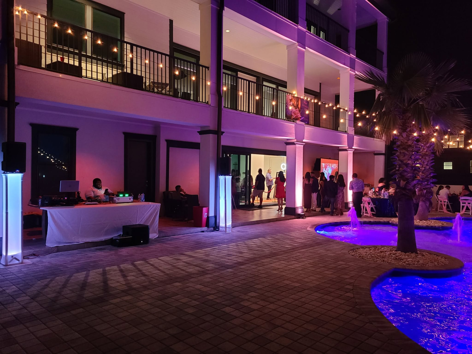 Courtyard wedding reception with DJ booth and purple uplighting by RTA Productions