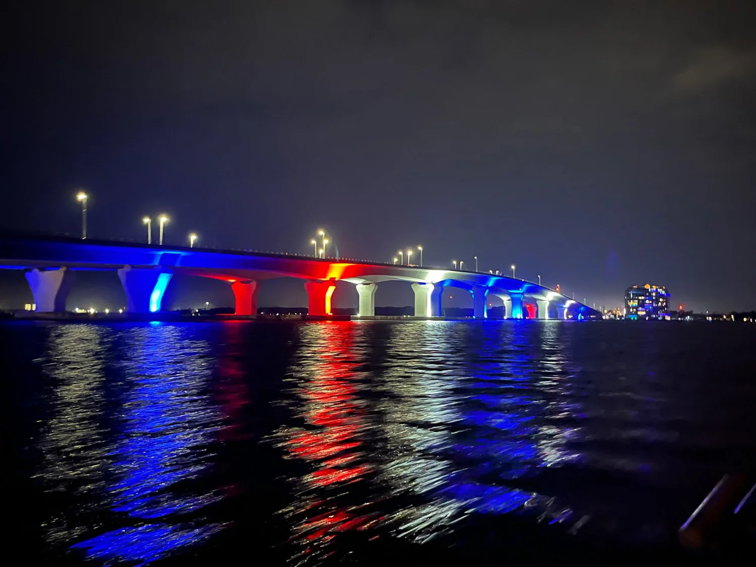 Architectural lighting reflecting across the bay at night